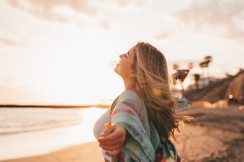 Woman relaxed and calm on beach - Calm Mind - Hypnotherapy for Anxiety